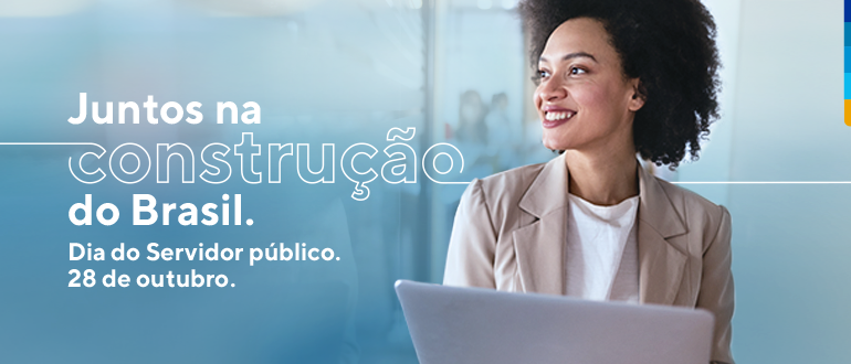 Fundo azul, com a foto de uma mulher negra com camiseta branca e terno bege, de pé, segurando notebook branco. E escrito no banner: Juntos na construção do Brasil. Dia do servidor público. 28 de Outubro.