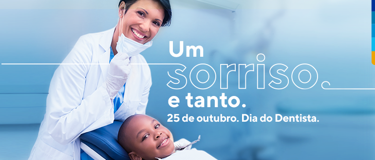 Fundo azul, com jovem dentista em pé puxando a máscara para baixo, exibindo sorriso, e jovem paciente sentado na cadeira de dentista sorrindo.