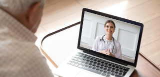 Paciente idoso em frente ao notebook, realizando consulta por telemedicina