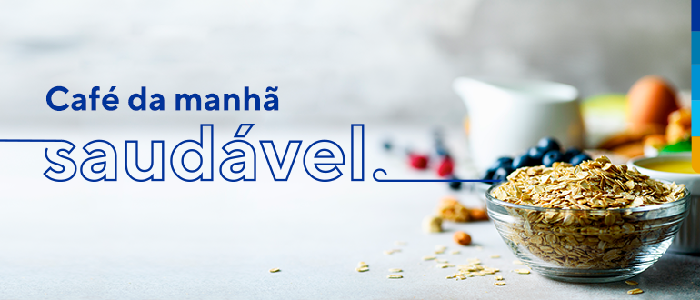Mesa branca com pote de cereais em primeiro plano, ao fundo diversas frutas, e ao lado esquerdo o texto: Café da manhã saudável