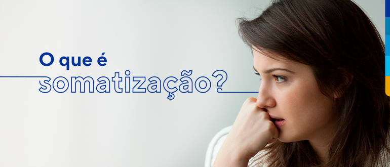 Texto: O que é somatização?
Ao lado, imagem de mulher com a mão no queixo olhando para o lado.