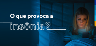 Texto: O que provoca a insônia? Ao lado, mulher sentada na cama olhando o celular.