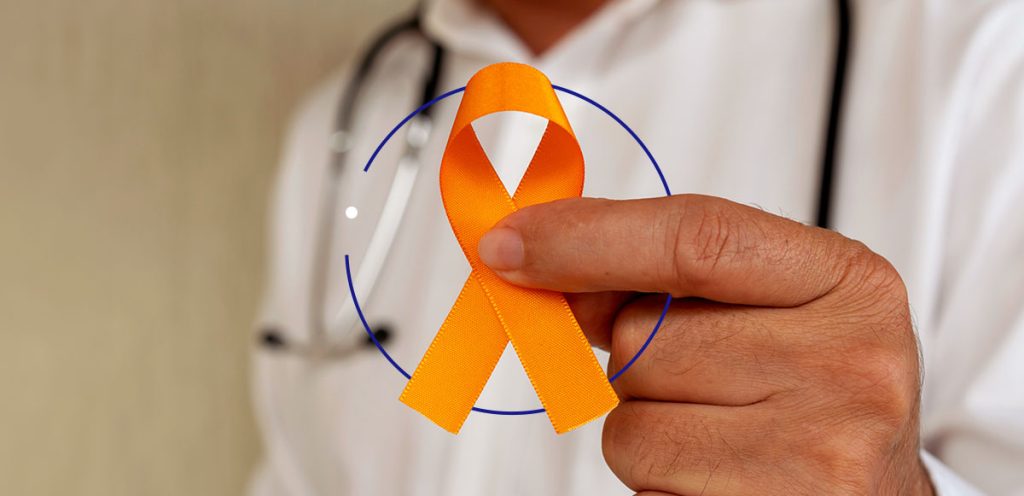 mão de um médico segurando uma fita laranja, simbolizando fevereiro laranja, combate e conscientização à Leucemia