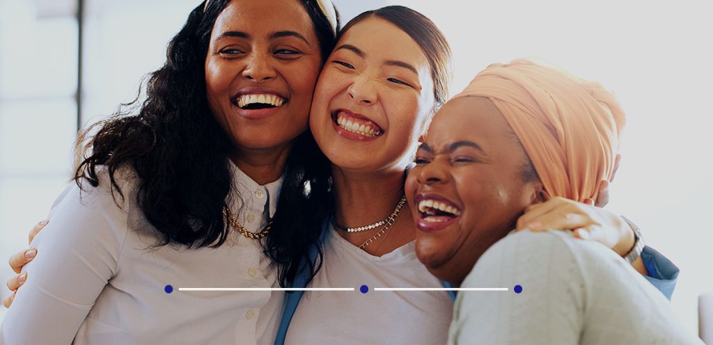 Imagem de três mulheres se abraçando, simbolizando o dia internacional da mulher