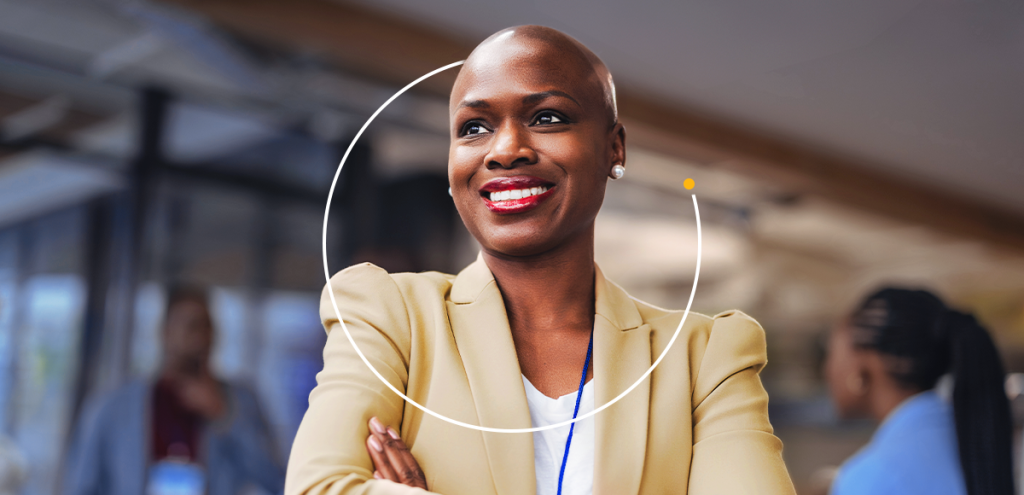 Imagem de uma mulher sorrindo e cruzando os braços para representar: Dia Internacional da Mulher: networking feminino.