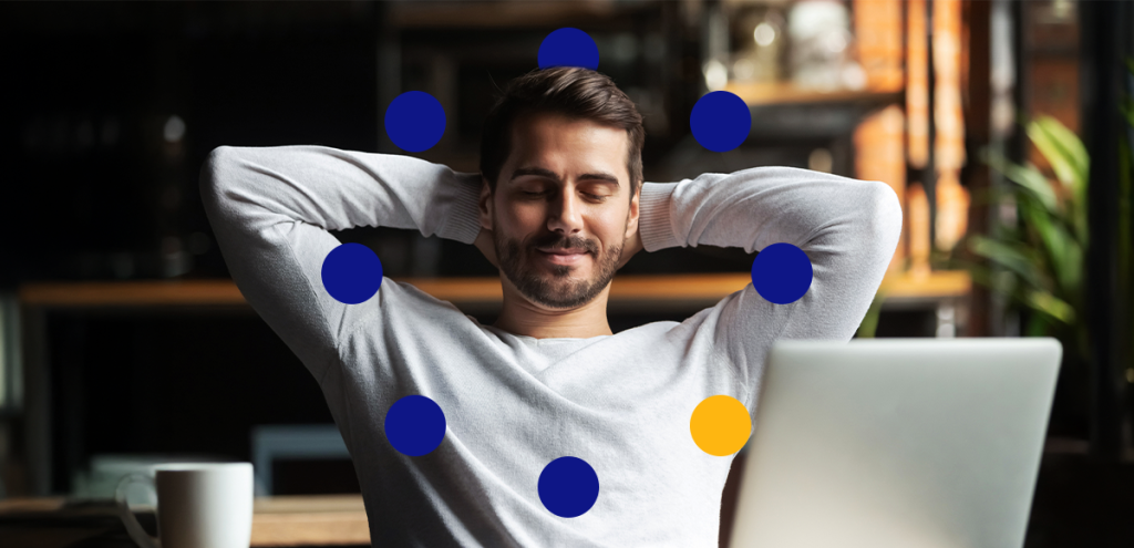 Imagem de um homem confortável olhando para o seu computador de forma tranquila para representar: saúde mental no ambiente de trabalho 